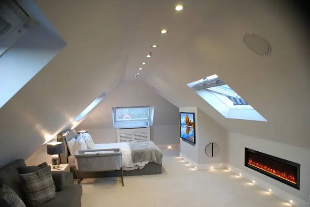 High-spec loft bedroom retreat with roof lights and feature fire