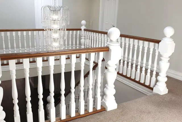 Renovated stair landing with white balustrade and feature chandelier